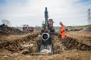 A_section_of_pipe_is_lowered_into_the_ground_1.jpg